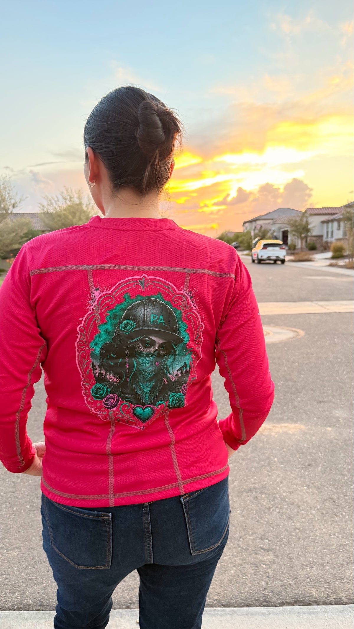 Women's pink performance long sleeve work shirt with a detailed graphic of a woman in a hard hat on the back.